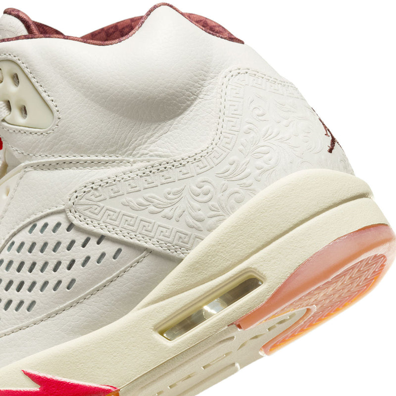 Exclusive AJ5 sneakers celebrating Mexico's heritage, featuring laser-cut leather, embossed patterns, asymmetrical midsole flames, off-white leather, and red and green lace locks, with a "VIVA" dubrae.


