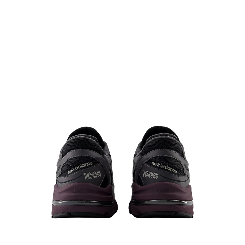 New Balance "Grey Day" inspired grey and black sneaker with plum midsole, leather and mesh construction, and signature "N" logo.