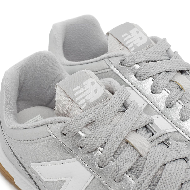 New Balance Wmns URC42CA sneaker with silver metallic leather upper, contrasting N logo, EVA cushioning, and breathable mesh lining for comfort and style.