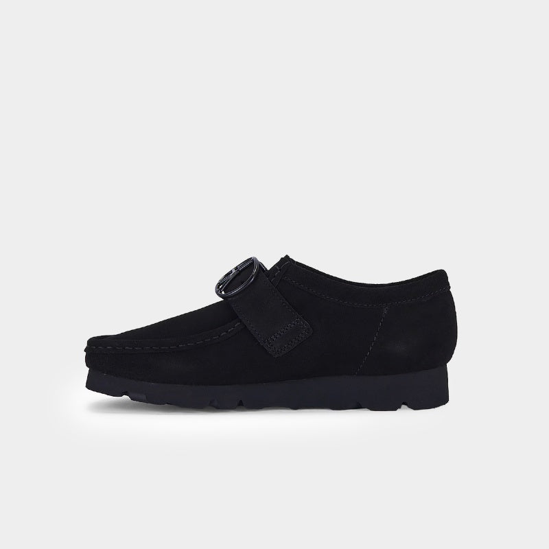 Clarks x Needles Wallabee boot featuring suede upper, debossed butterfly detail, and metal peace sign buckle on adjustable strap.