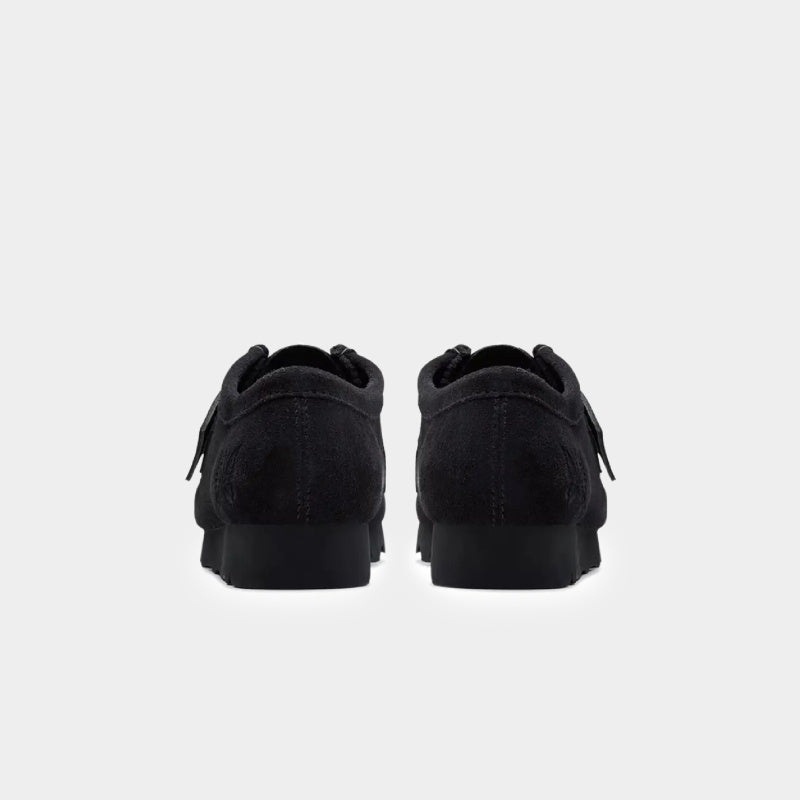 Clarks x Needles Wallabee boot featuring suede upper, debossed butterfly detail, and metal peace sign buckle on adjustable strap.