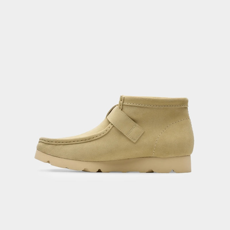 Clarks x Needles Wallabee boot featuring suede upper, debossed butterfly detail, and metal peace sign buckle on adjustable strap.