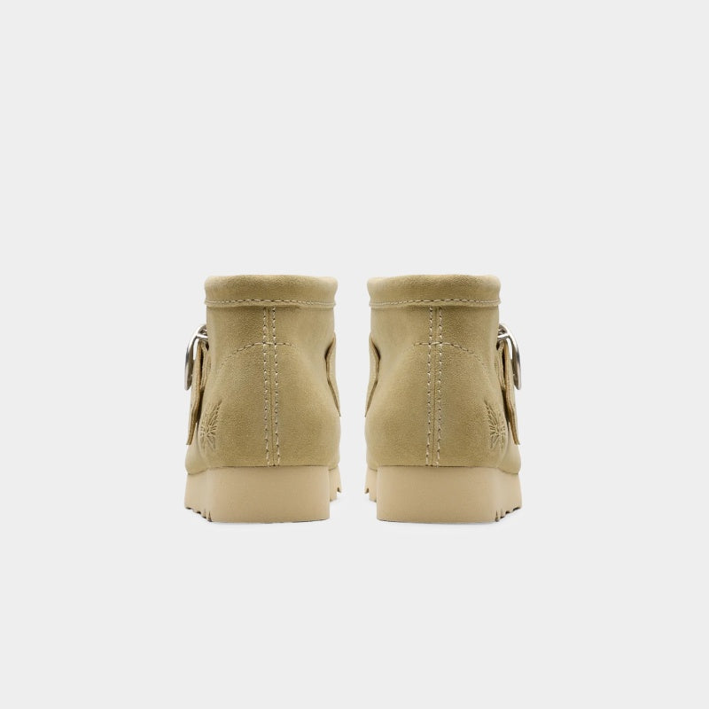 Clarks x Needles Wallabee boot featuring suede upper, debossed butterfly detail, and metal peace sign buckle on adjustable strap.