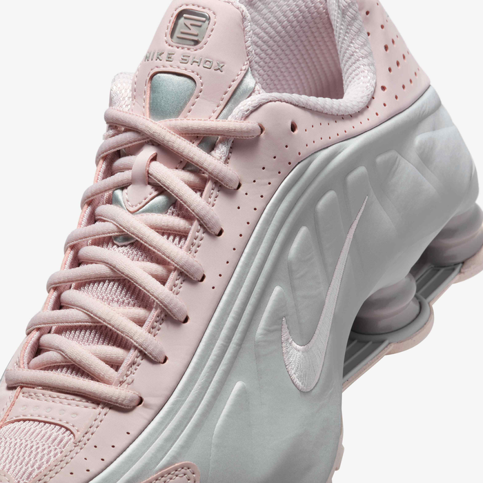 Nike Shox R4 sneaker with synthetic and textile upper, design lines, laser perforations, and Nike Shox cushioning, offering a performance-inspired aesthetic and maximum comfort.