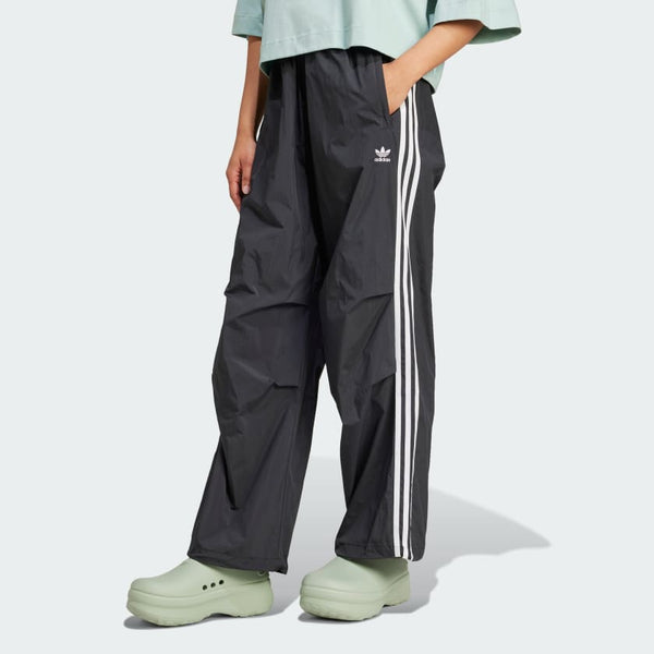 Adidas parachute pants with a relaxed fit and iconic 3-Stripes, designed for comfort and sporty style.
