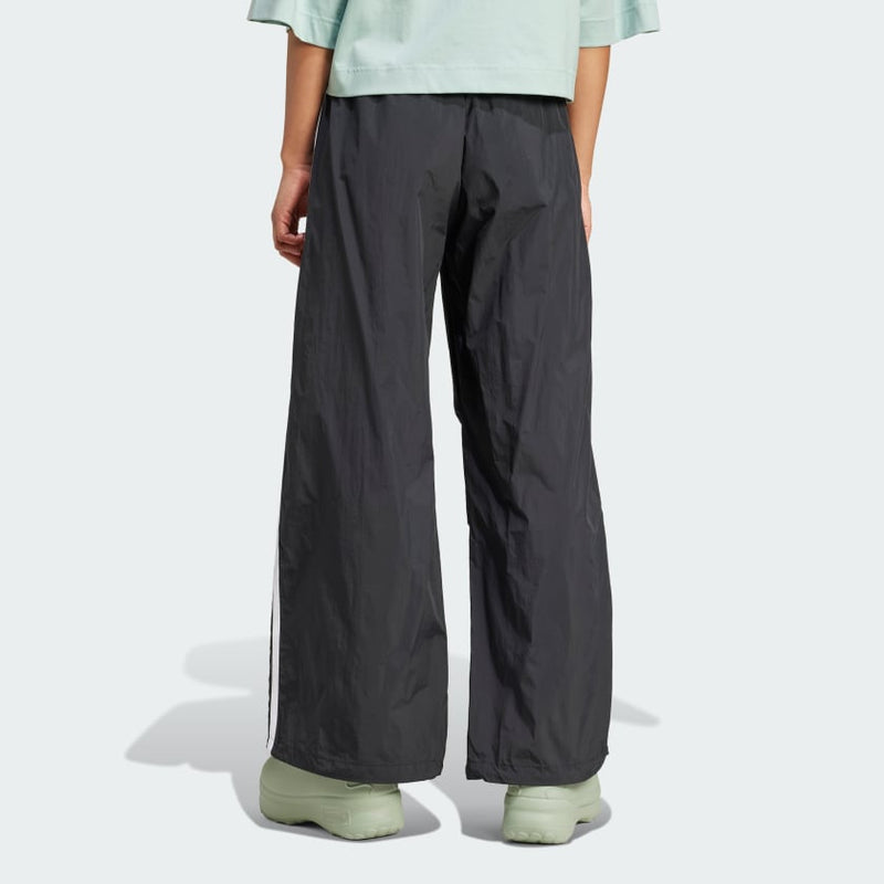 Adidas parachute pants with a relaxed fit and iconic 3-Stripes, designed for comfort and sporty style.