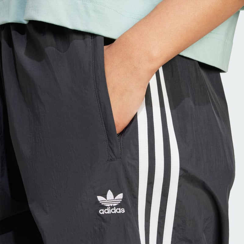 Adidas parachute pants with a relaxed fit and iconic 3-Stripes, designed for comfort and sporty style.