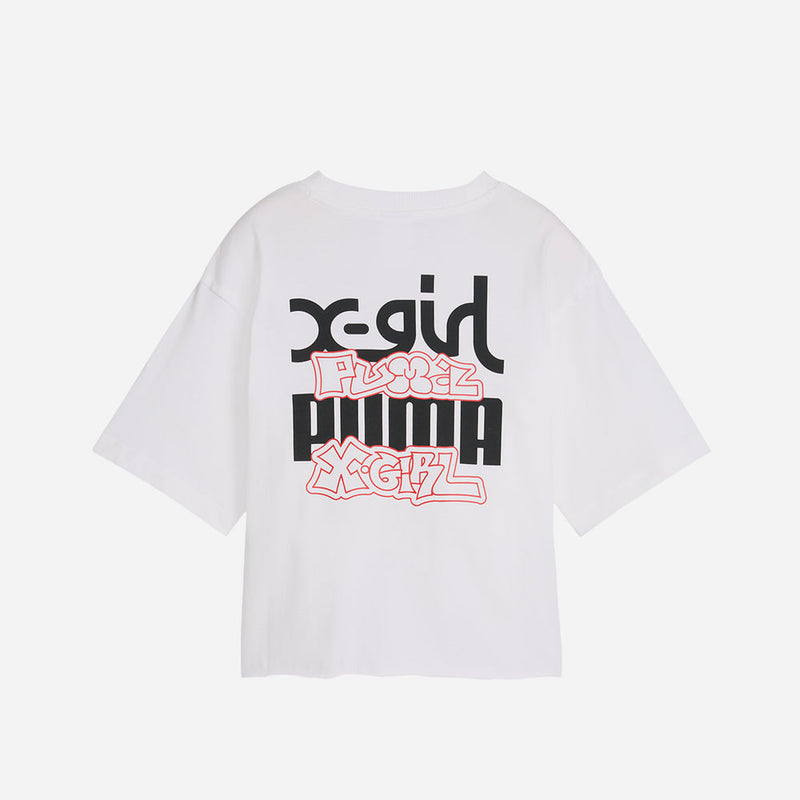 PUMA x X-GIRL tee featuring bold rubber print graphic on the front and contrast stitching, showcasing a modern streetwear style with a graffiti-inspired, DIY vibe.