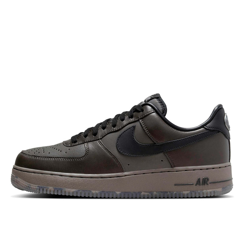 Refreshed AF-1 sneaker in dark tones with premium Black Tea and Petra Brown leather, marbled Olive Grey outsole, and sleek plated heel branding. Features Nike Air cushioning for enhanced comfort.