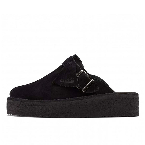 Clarks Originals Trek wedge heel mules in black suede, showcasing a slip-on design with an adjustable pin-buckle strap, center split seam, and rounded toeline.