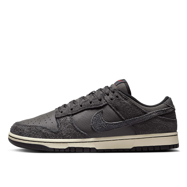 Premium Dunk Low sneaker with Medium Ash tumbled leather, black and Off-Noir shaggy suede overlays, and a timeless, statement-making design.