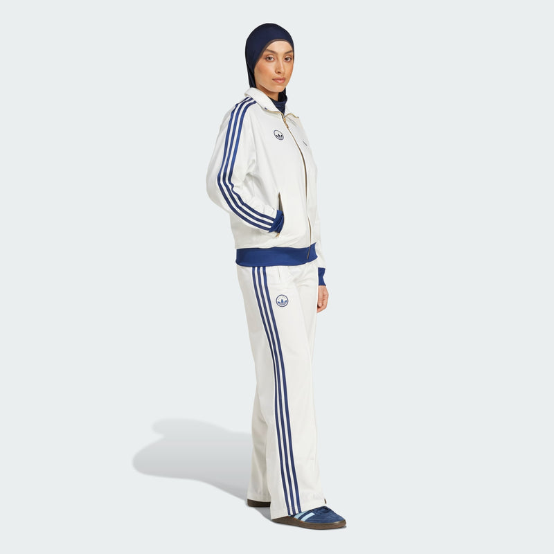 Adidas Firebird track pants featuring classic 3-Stripes, signature tricot sheen, and colors inspired by international competition, embodying a timeless sports style.



