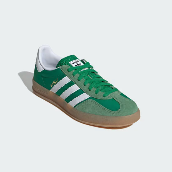 Close-up of The Gazelle Indoor shoes, showcasing their premium suede upper and gum rubber outsole. The design includes the iconic Trefoil logo and serrated 3-Stripes, blending contemporary style with a classic football training aesthetic.