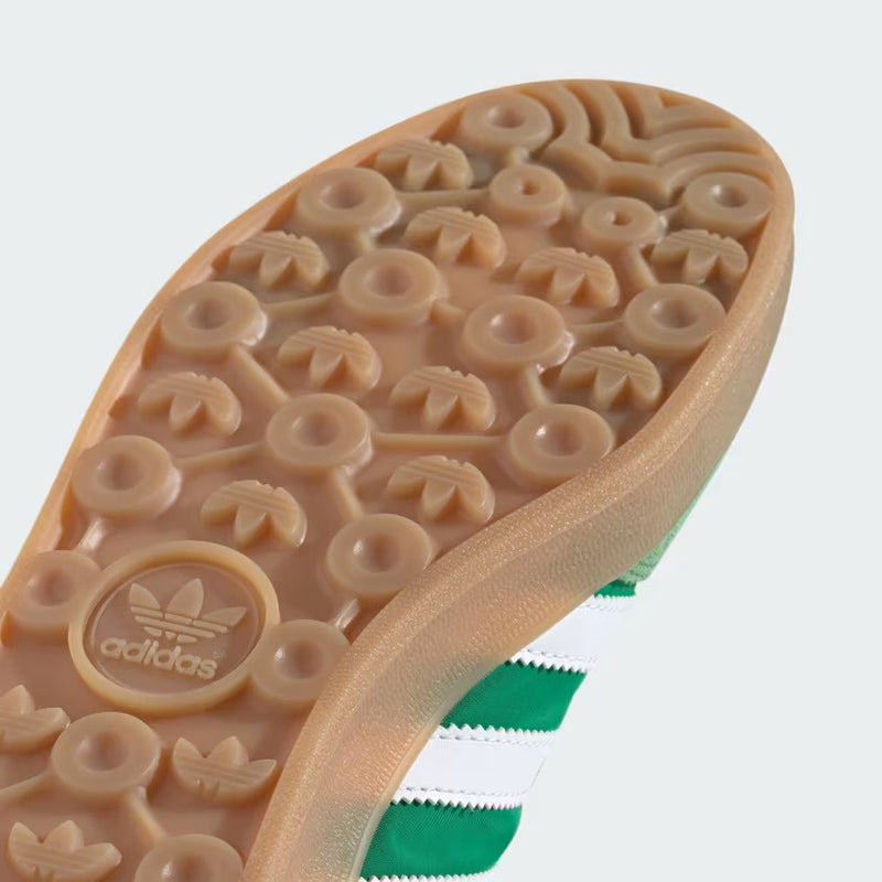Close-up of The Gazelle Indoor shoes, showcasing their premium suede upper and gum rubber outsole. The design includes the iconic Trefoil logo and serrated 3-Stripes, blending contemporary style with a classic football training aesthetic.