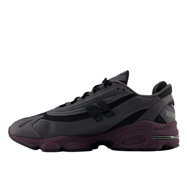New Balance "Grey Day" inspired grey and black sneaker with plum midsole, leather and mesh construction, and signature "N" logo.