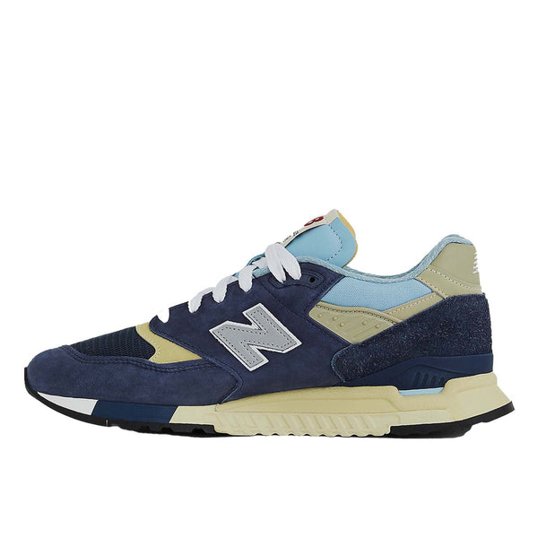 New Balance 998 Made in USA sneakers in navy with chrome blue accents, featuring ABZORB cushioning and premium suede, mesh, and hairy suede construction.