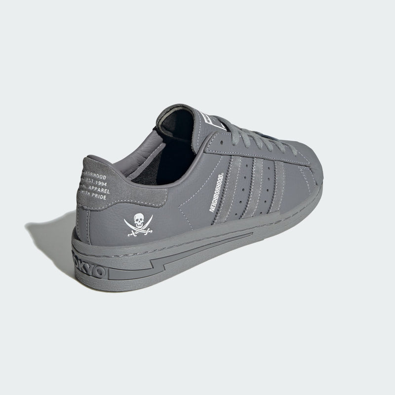 adidas Superstar x NEIGHBORHOOD sneakers with matte black leather, white stitching, and debossed logo and skull graphic.