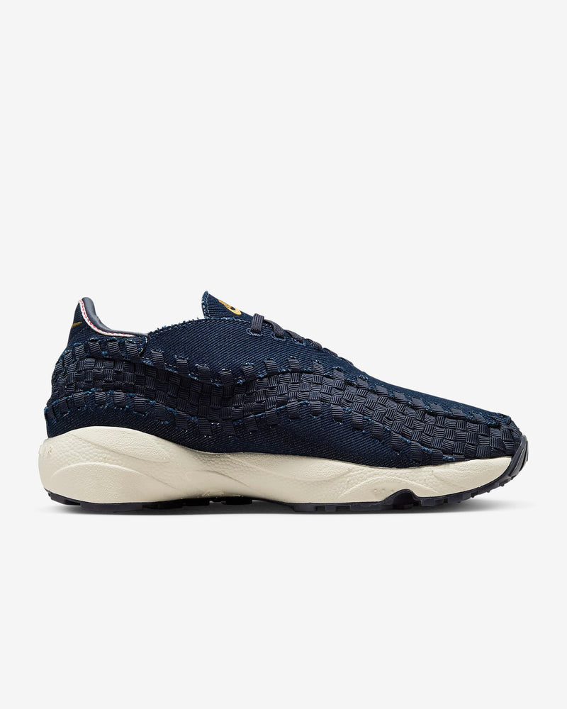 Air Footscape Woven denim sneaker with roomy toe box, lateral lacing, foam midsole, and Nike Air cushioning.