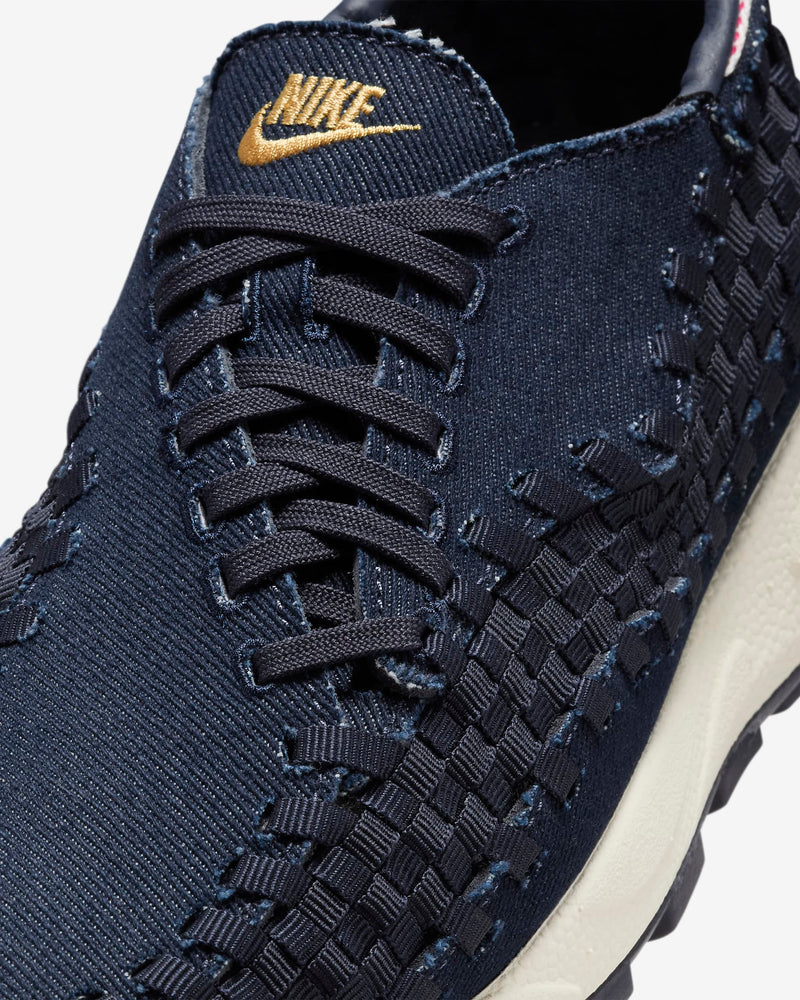 Air Footscape Woven denim sneaker with roomy toe box, lateral lacing, foam midsole, and Nike Air cushioning.