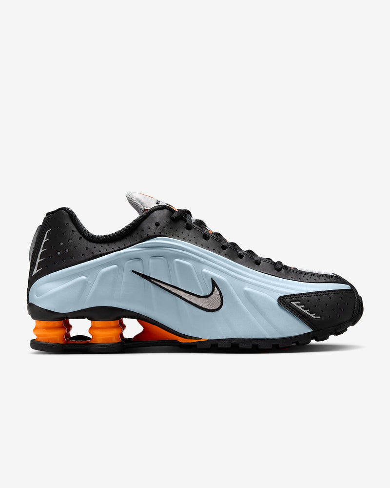 Nike Shox R4 sneakers in silver and red with signature Shox heel cushioning.