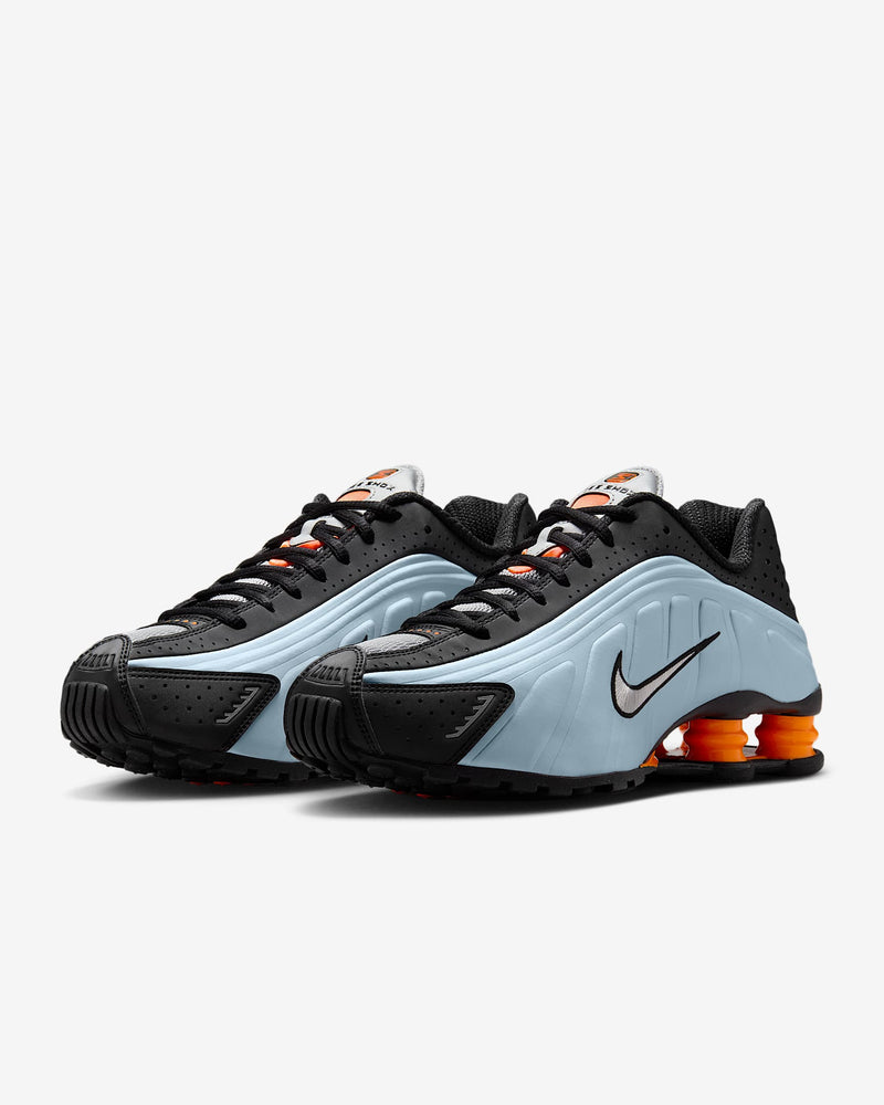 Nike Shox R4 sneakers in silver and red with signature Shox heel cushioning.