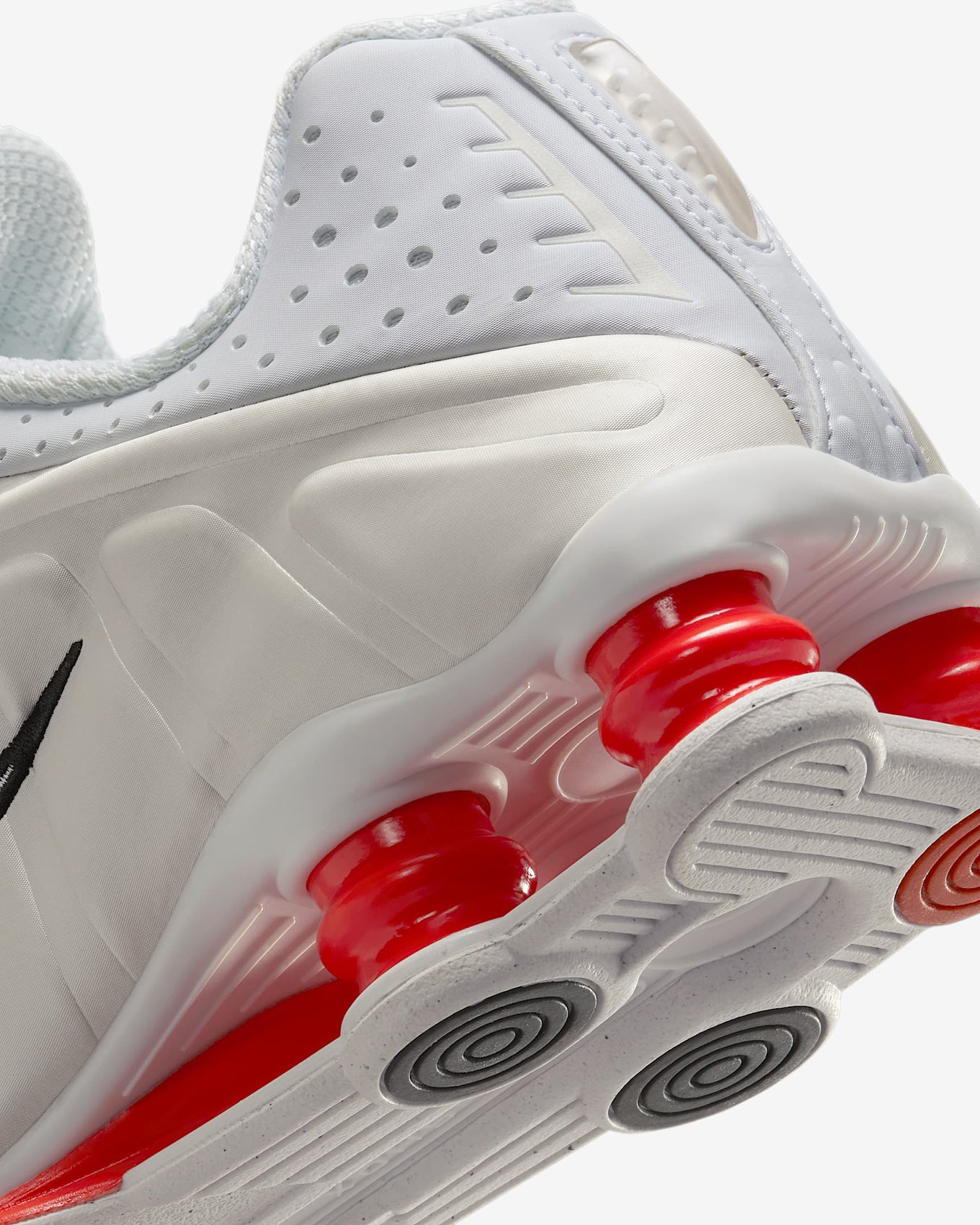 Nike Shox R4 shoes with synthetic and textile upper, laser perforations, and signature Shox cushioning columns in the heel