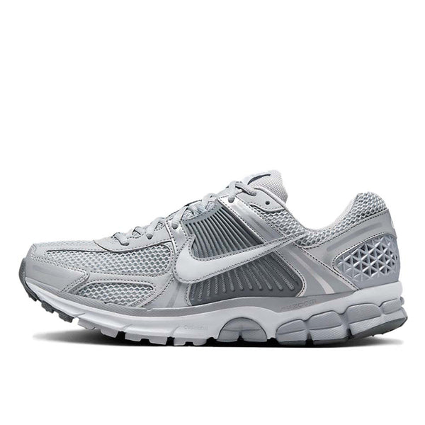 Nike Zoom Vomero with Wolf Grey, White, Metallic Silver, Cool Grey, and Metallic Platinum tones, featuring a breathable mesh upper, leather overlays, plastic lace cage, honeycomb heel counter, and 3M reflective accents.