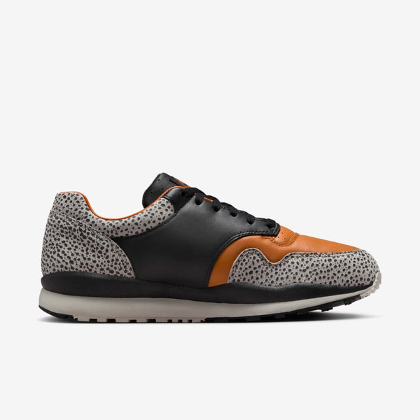 Nike Air Safari OG sneaker with safari print on toe box and heel, black and monarch leather upper, light iron ore midsole, and black rubber outsole.


