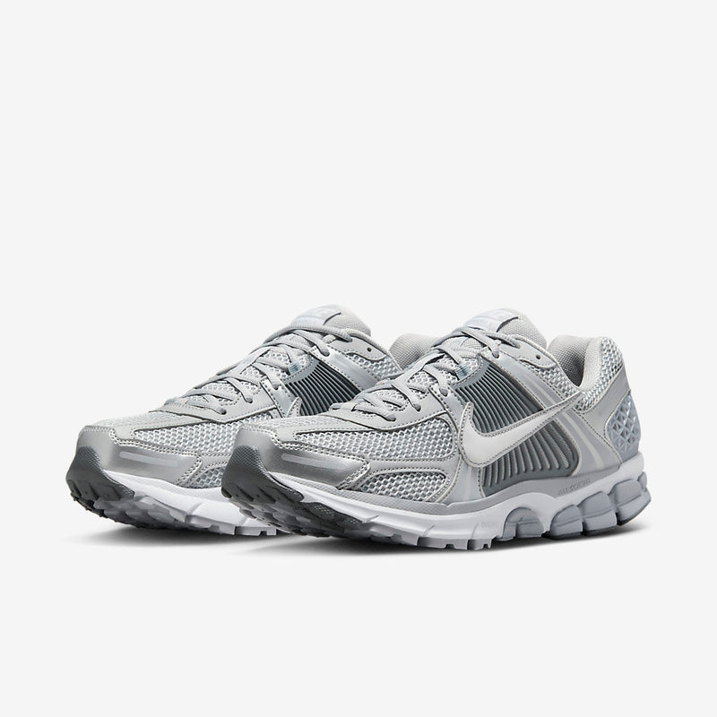 Nike Zoom Vomero with Wolf Grey, White, Metallic Silver, Cool Grey, and Metallic Platinum tones, featuring a breathable mesh upper, leather overlays, plastic lace cage, honeycomb heel counter, and 3M reflective accents.