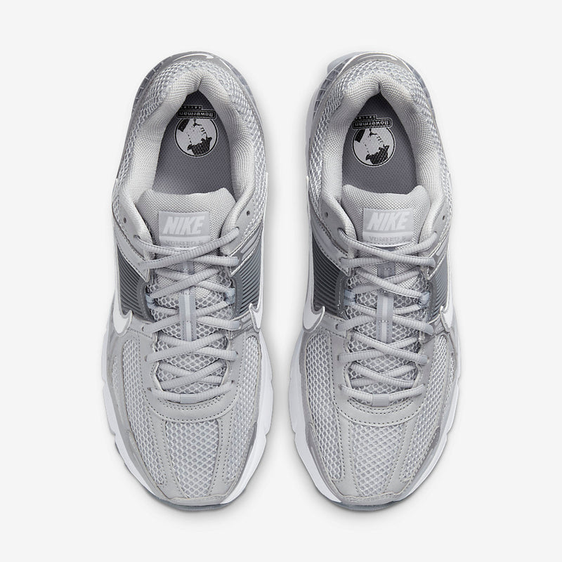 Nike Zoom Vomero with Wolf Grey, White, Metallic Silver, Cool Grey, and Metallic Platinum tones, featuring a breathable mesh upper, leather overlays, plastic lace cage, honeycomb heel counter, and 3M reflective accents.