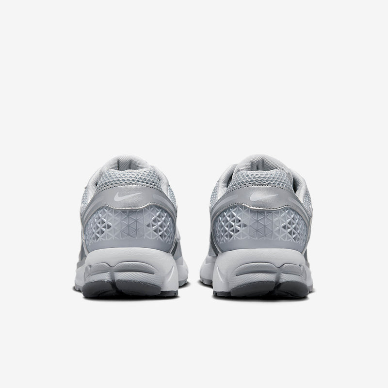 Nike Zoom Vomero with Wolf Grey, White, Metallic Silver, Cool Grey, and Metallic Platinum tones, featuring a breathable mesh upper, leather overlays, plastic lace cage, honeycomb heel counter, and 3M reflective accents.