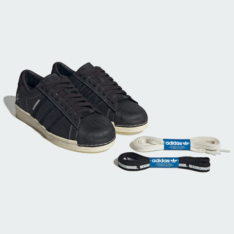 Adidas Superstar x NEIGHBORHOOD 30th Anniversary edition sneakers with matte black leather, white stitching, and iconic skull graphic.