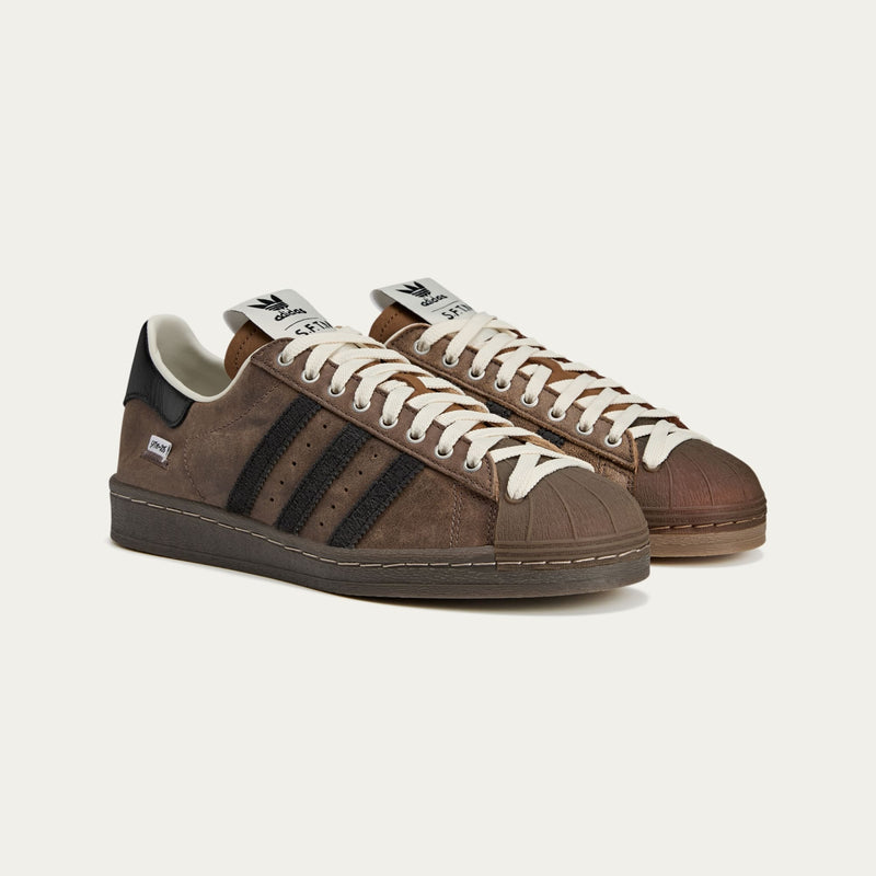 adidas Superstar x Song for the Mute sneakers with a collapsible upper, extended eyelets, and iconic rubber shell toe, blending classic and contemporary design.