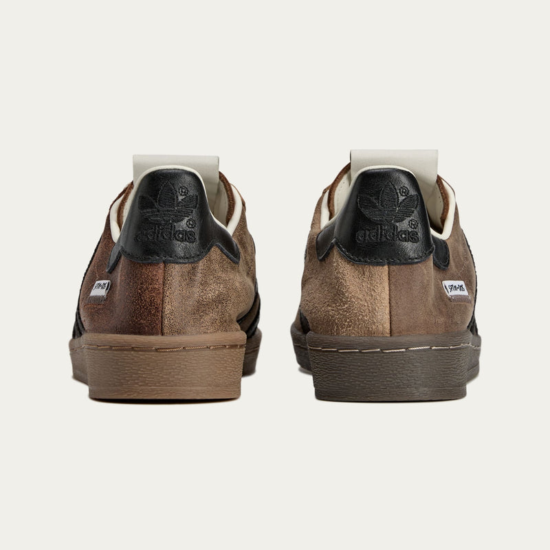 adidas Superstar x Song for the Mute sneakers with a collapsible upper, extended eyelets, and iconic rubber shell toe, blending classic and contemporary design.