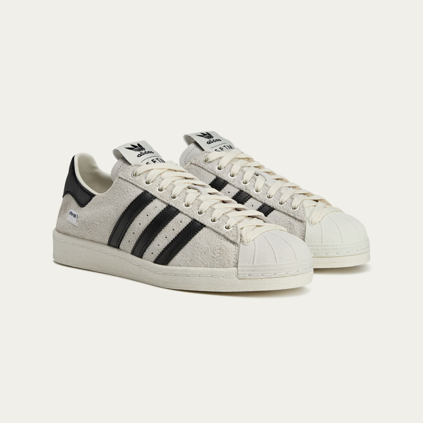 adidas Superstar x Song for the Mute sneakers with a collapsible upper, extended eyelets, and iconic rubber shell toe, blending classic and contemporary design.