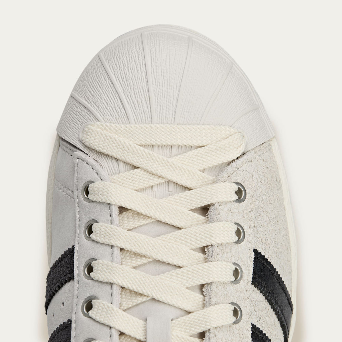 adidas Superstar x Song for the Mute sneakers with a collapsible upper, extended eyelets, and iconic rubber shell toe, blending classic and contemporary design.