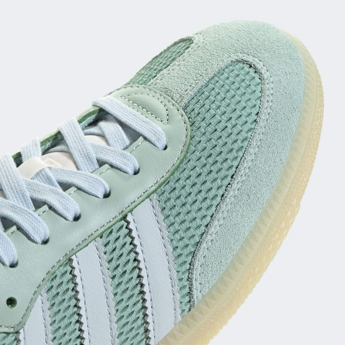 adidas Samba OG sneaker with a mesh-textured leather upper, classic T-toe overlay, and stitched heel tab, embodying vintage style with modern comfort.