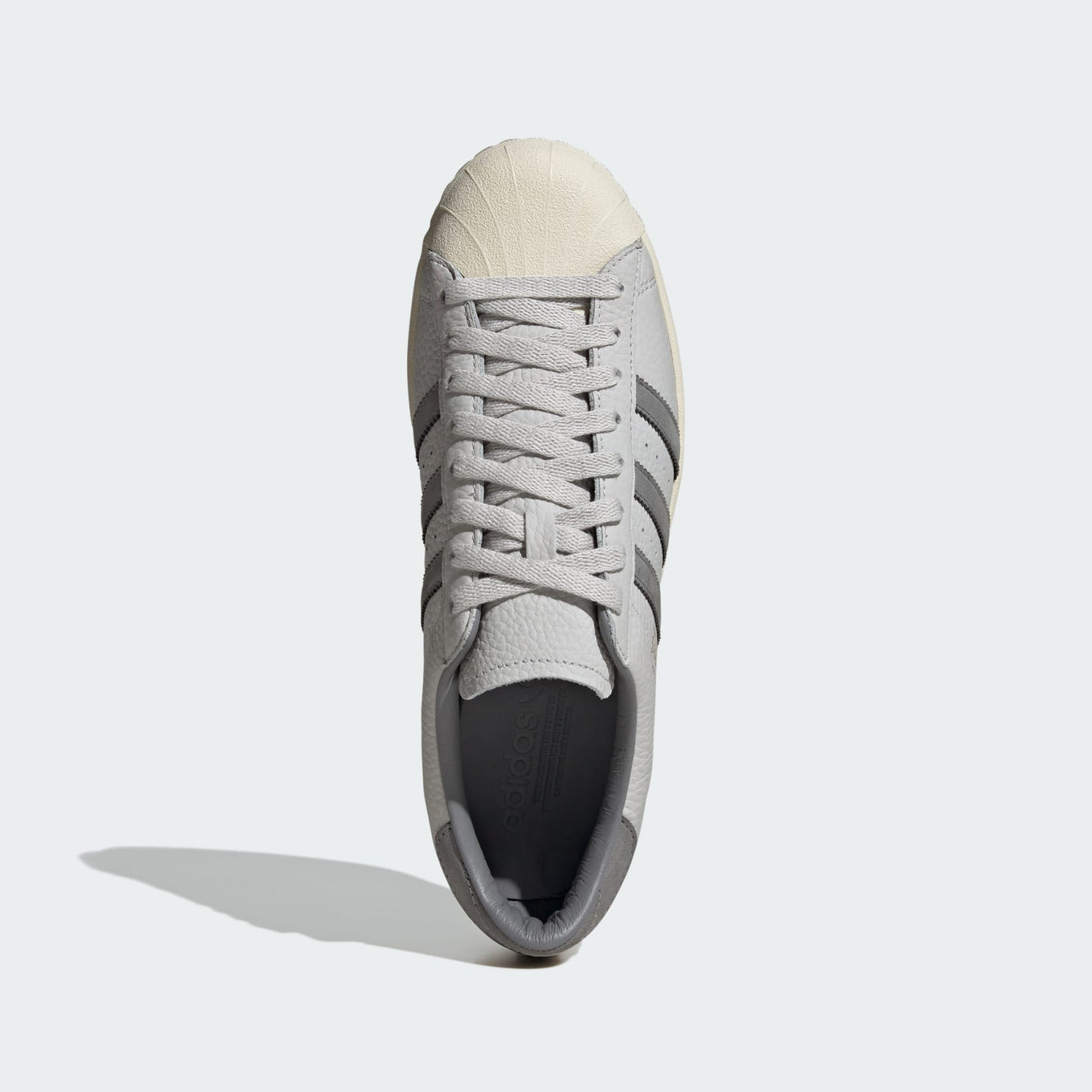 Grey adidas Superstar shoes with tonal shades and gold foil branding, inspired by the original 1969 design