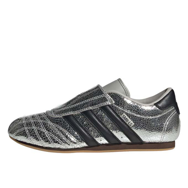 adidas Taekwondo trainers with a cracked metallic leather upper, slip-on design, and low-profile rubber outsole for a sleek, streetwear-inspired look.