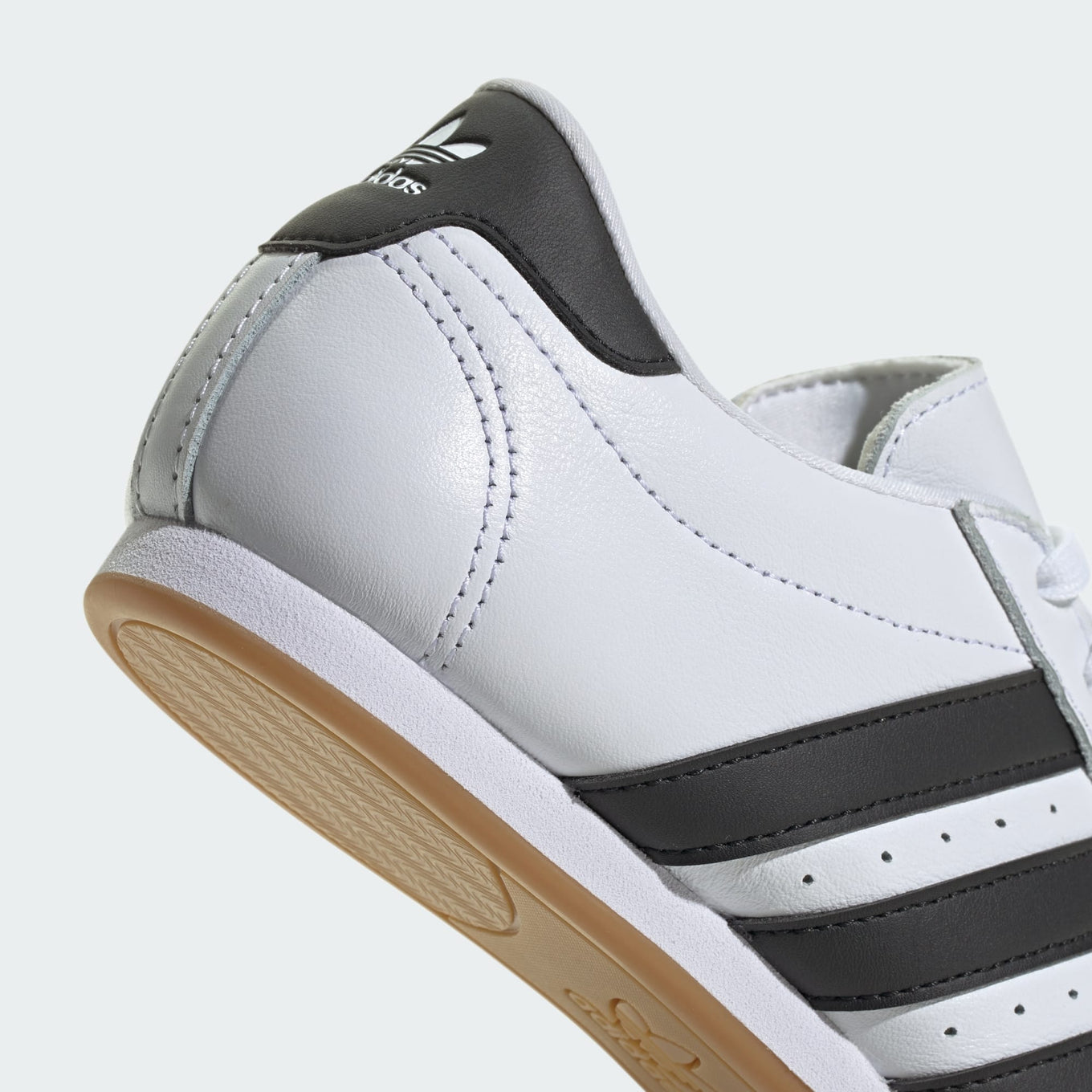 Sleek adidas trainers with minimalist design, soft leather, quilted toes, and classic 3-Stripes