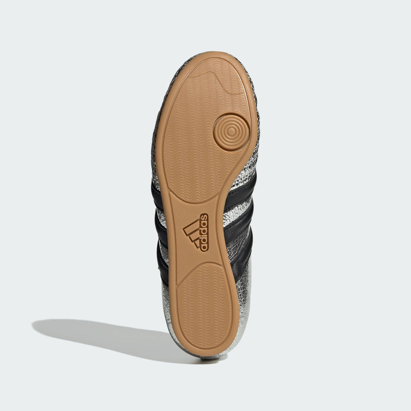 adidas Taekwondo trainers with a cracked metallic leather upper, slip-on design, and low-profile rubber outsole for a sleek, streetwear-inspired look.