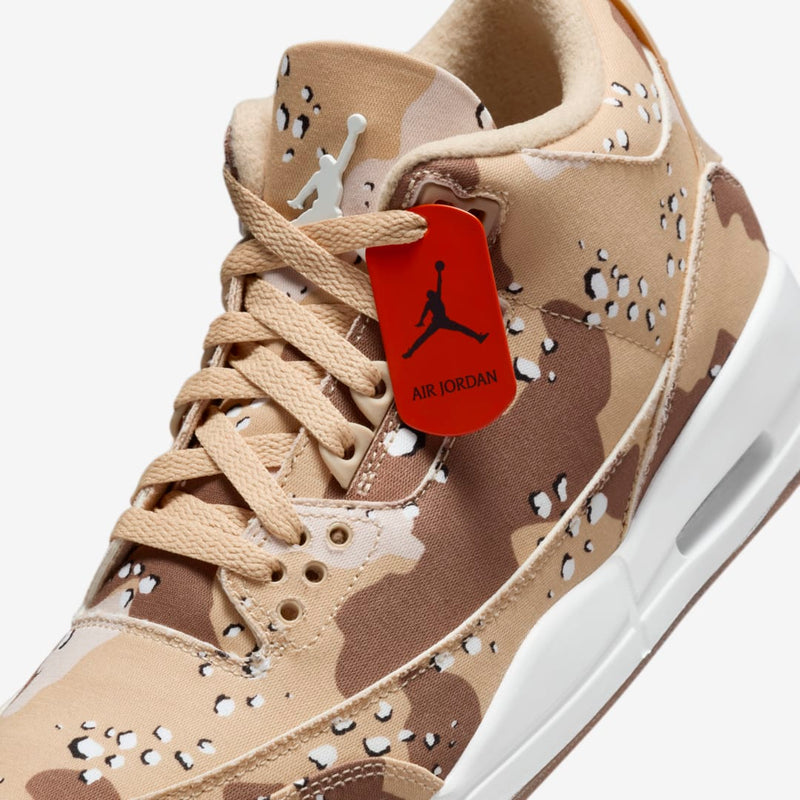 Desert Camo edition of the AJ3 sneakers with textured textile upper, raised Jumpman logo on tongue, Brilliant Orange accents on sole, and matching dog tag for laces