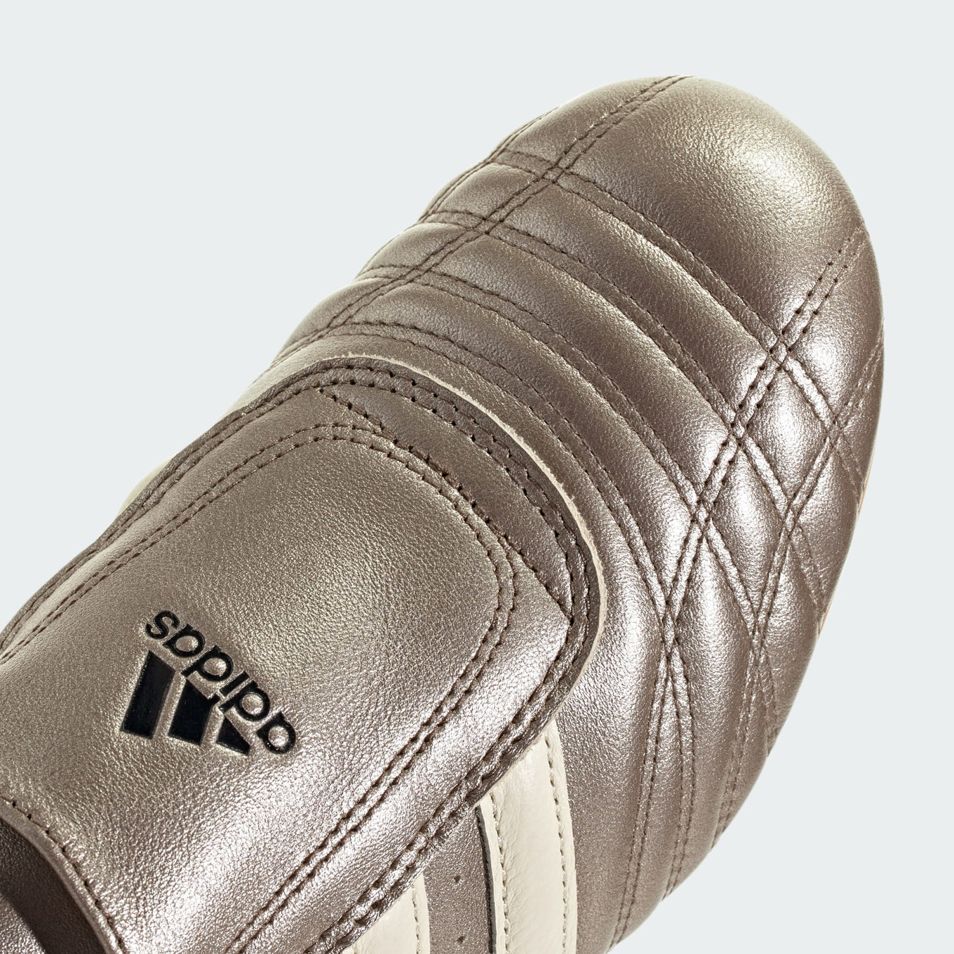 adidas Taekwondo slip-on shoes with a glossy quilted leather upper, ultra-low-profile sole, and signature 3-Stripes for a modern yet retro look.