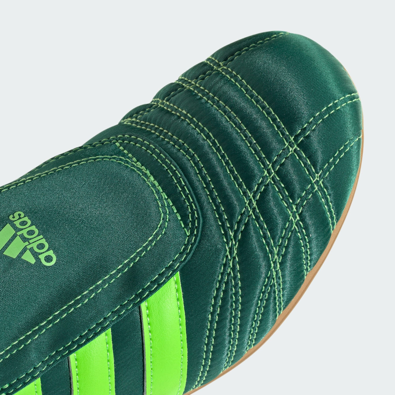 adidas slip-on shoes with smooth upper, curved stitching, and low-profile design inspired by 2000s Taekwondo trainers