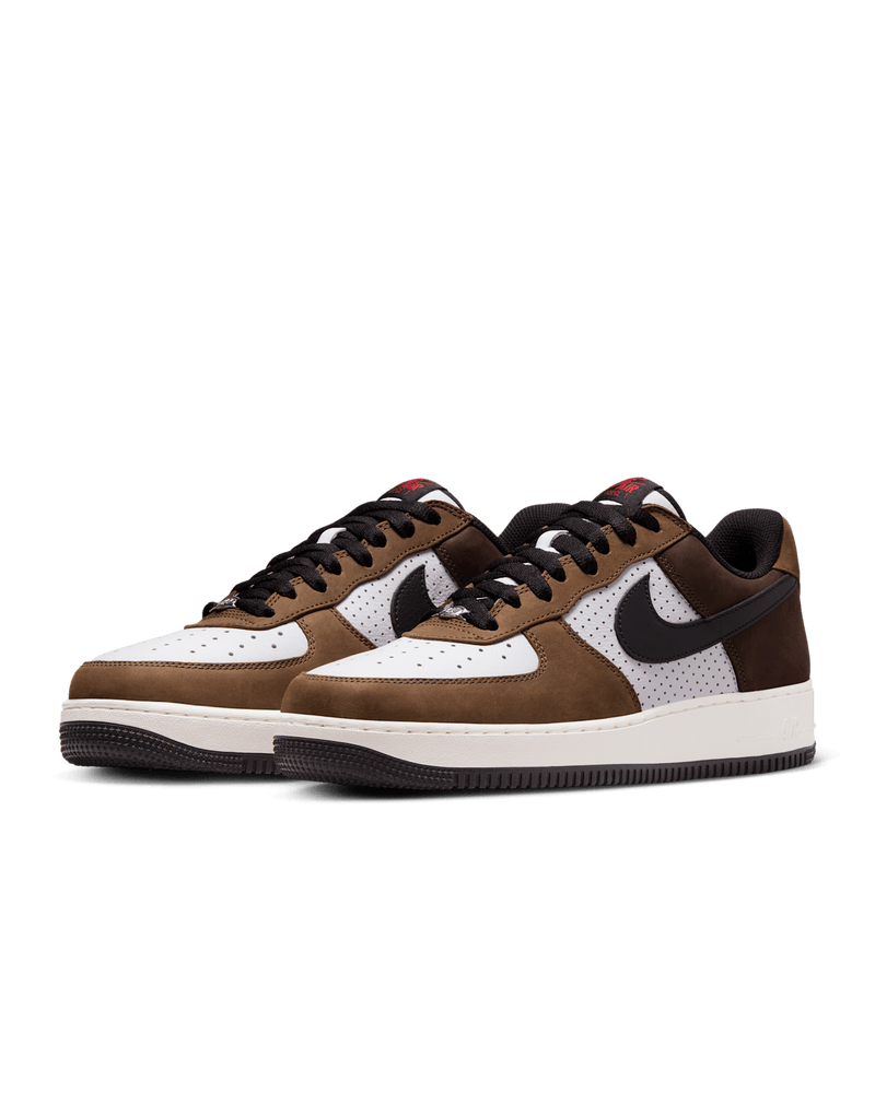 Nike Air Force 1 “Escape” with white leather upper, brown accents, and red tongue logo