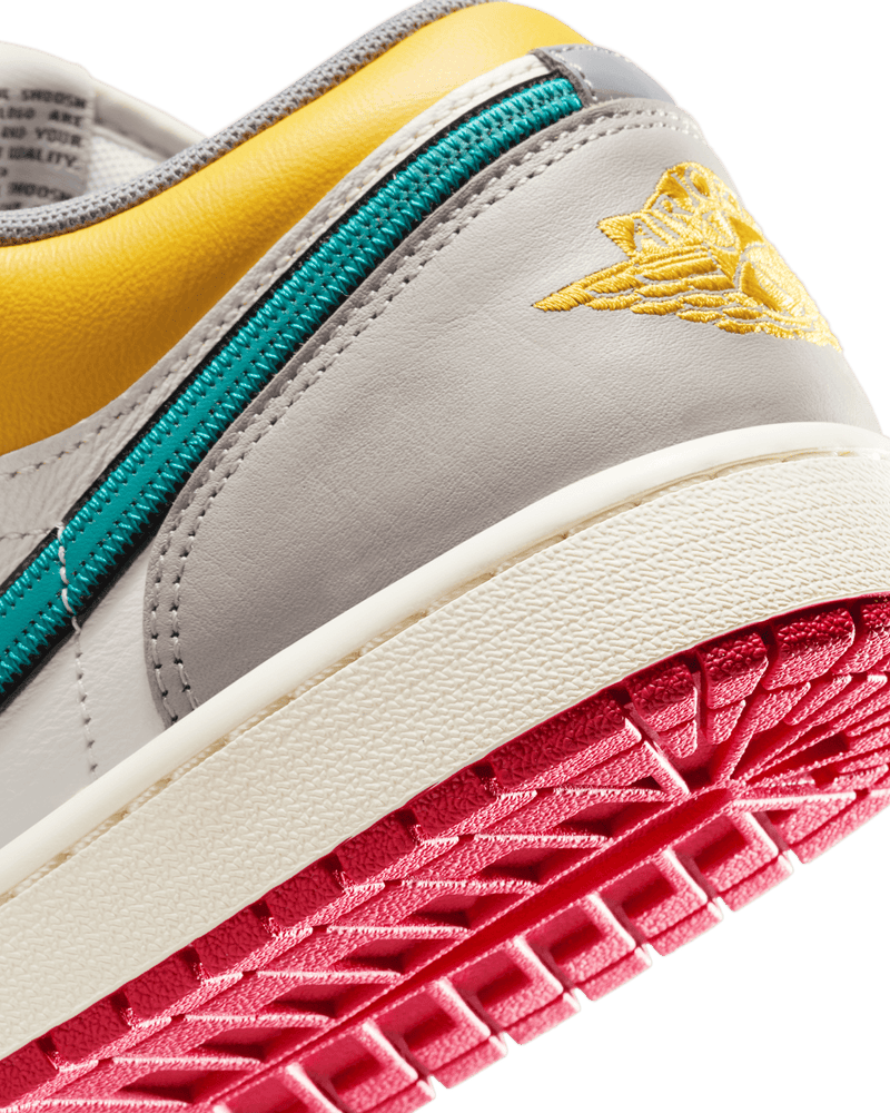 AJ1 Low Premium sneaker with Sail leather upper, Yellow Ochre and College Grey accents, dual-layered Swoosh logos, and Nike Air cushioning.