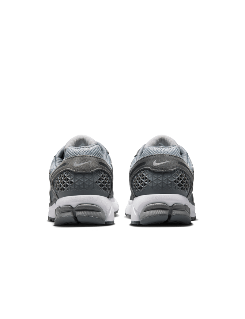 Zoom Vomero 5 with layered leather and textiles, Zoom Air cushioning, mesh panels, and durable rubber outsole.