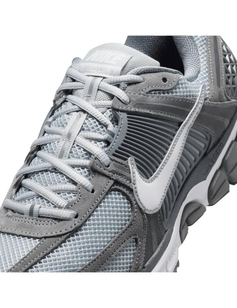 Zoom Vomero 5 with layered leather and textiles, Zoom Air cushioning, mesh panels, and durable rubber outsole.