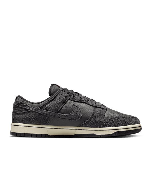 Premium Dunk Low sneaker with Medium Ash tumbled leather, black and Off-Noir shaggy suede overlays, and a timeless, statement-making design.