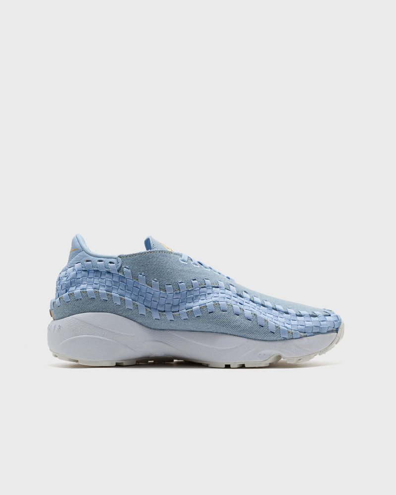 Nike Footscape Woven in monochromatic denim with woven "blue jeans" pattern, rivet detail, and yellow stitching.